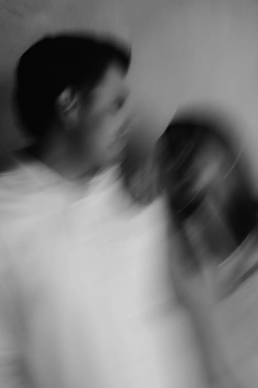 En blanco y negro, una pareja se abraza en movimiento, con efecto de desenfoque.
