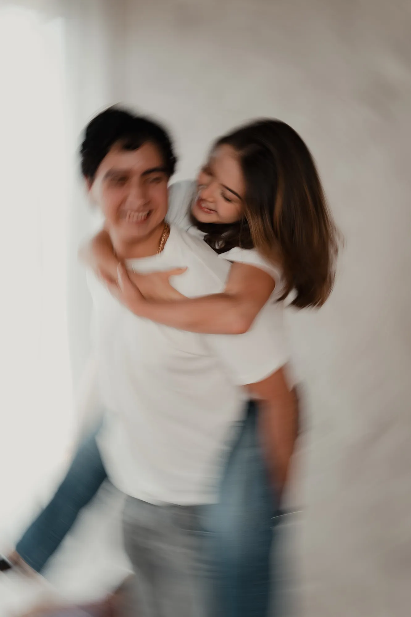 Una pareja se abraza y ríe, con efecto de movimiento.